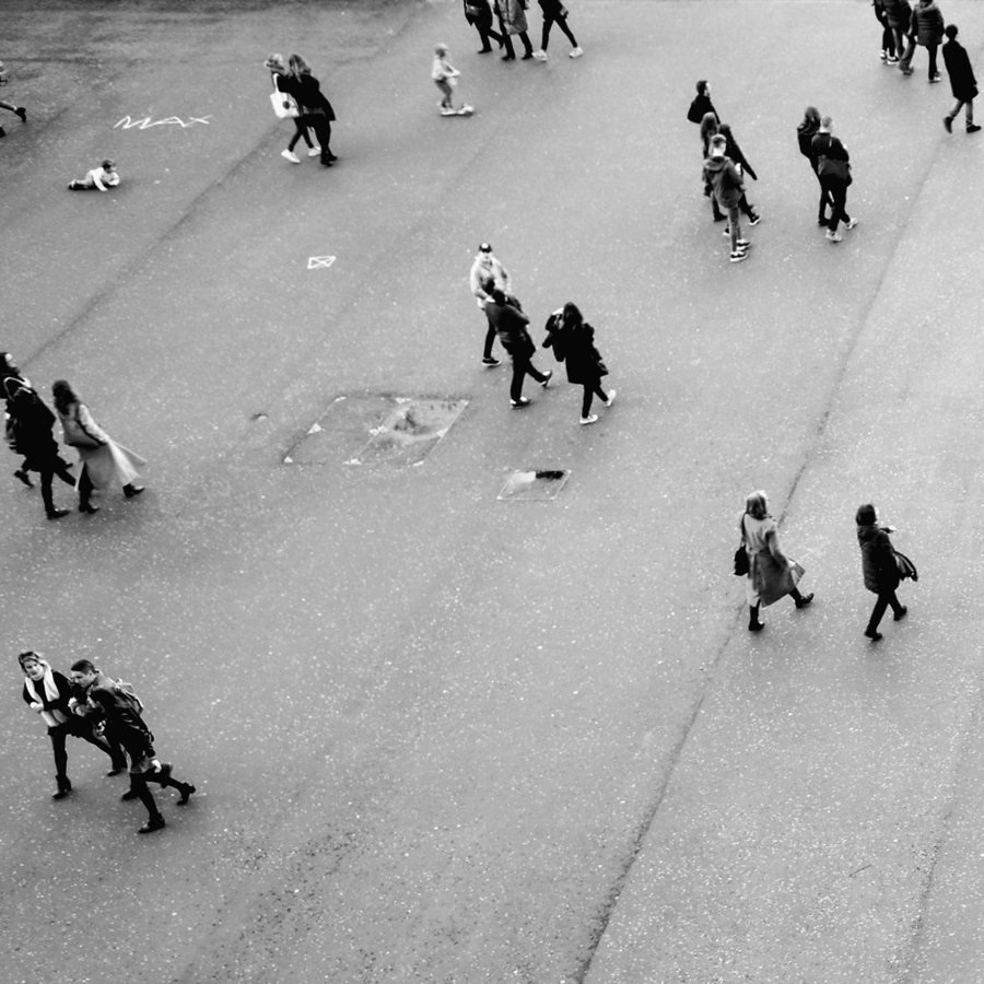 Personas caminando por una plaza, vistas desde arriba, en blanco y negro